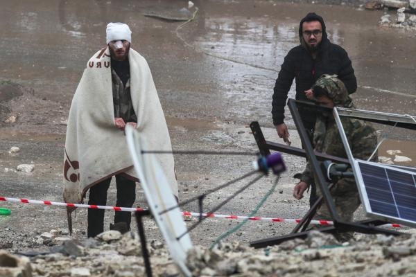 رجل جريح ينظر بينما يبحث رجال الإنقاذ عن ناجين تحت الأنقاضفي بلدة جندريس بسوريا - رويترز