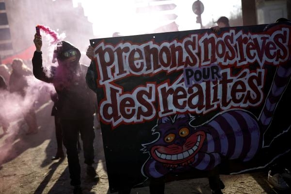 متظاهرون في فرنسا يرفعون لافتة كتب عليها 