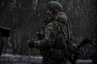 جندي أوكراني يحمل ذخيرة على طريق خارج بلدة باخموت على خط المواجهة، وسط هجوم روسي على أوكرانيا - رويترز