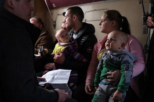 أوكرانية وطفلها داخل قطار إجلاء بعد مغادرة قريتهم قرب باخموت - رويترز