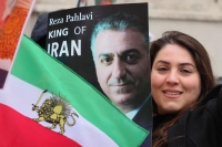 إيرانية تقف بجانب العلم وصورة الشاه باحتجاج في ألمانيا - رويترز