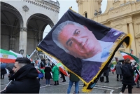 رجل يحمل علمًا بصورة الشاه محمد رضا بهلوي خلال احتجاج في يوم مؤتمر ميونيخ للأمن - رويترز
