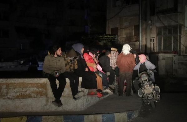 سوريون يجلسون في الشارع بعد الزلزال المميت في إدلب - رويترز