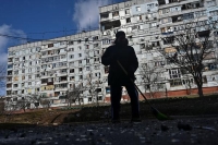 مواطن أوكراني يزيل الأنقاض أمام مبنى سكني تضرر من غارة عسكرية روسية - رويترز