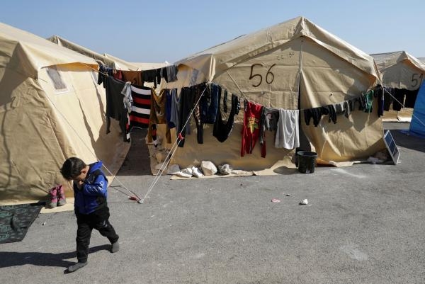 طفل يسير خارج مخيم للناجين من الزلزال بسوريا - رويترز