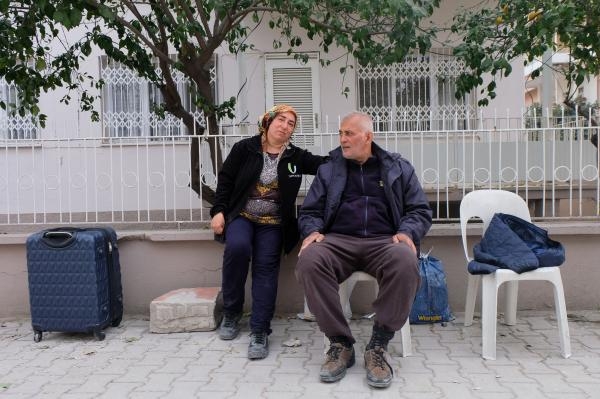 الناجيان ريحان فورال وزوجها متين يجلسان على كراسي بلاستيكية في مواجهة أنقاض منزلهما في عثمانية بتركيا- رويترز