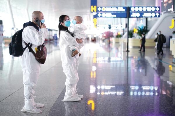 مسافرون صينيون في مطار ووهان بعد رفع الإغلاق - رويترز