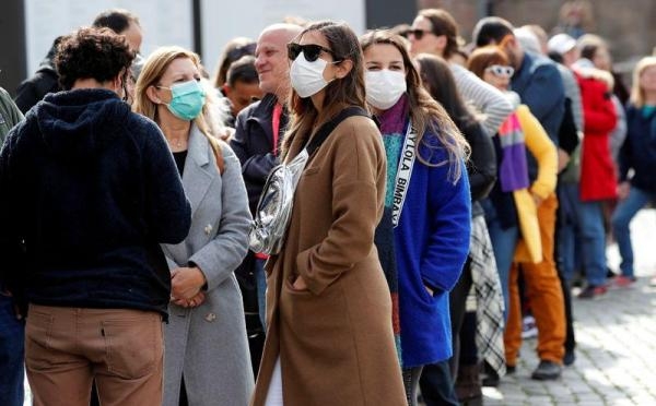 أشخاص يرتدون كمامات للوقاية من الإصابة بفيروس كورونا - رويترز