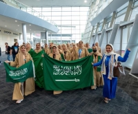 طالبات المملكة يحملن العلم السعودي خلال حفل افتتاح 