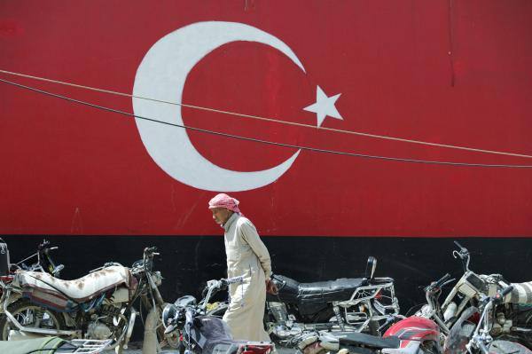 رجل يسير وخلفه علم تركيا - رويترز 