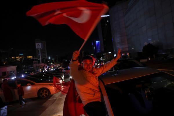 أحد الناخبين يحمل علم تركيا - رويترز