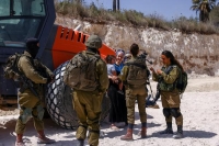 مستوطن وجنود إسرائيليون في موقع بالضفة الغربية (رويترز)