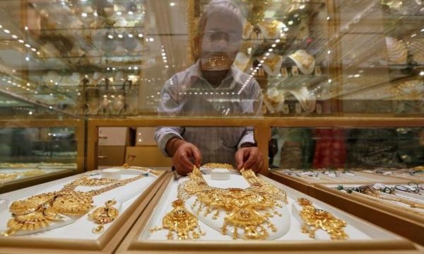 بائع يرتب عقدًا ذهبيًا داخل صالة عرض للمجوهرات - رويترز