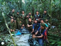 جنود من الجيش الكولومبي يقفون لالتقاط صورة بعد إنقاذ أطفال ناجين من تحطم طائرة- رويترز 