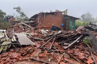رجال الإنقاذ يقفون بجوار حطام منزل سكني دمره الانهيار الأرضي- رويترز