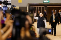 رئيس الوزراء الهندي ناريندرا مودي يلوح أثناء زيارته للمركز الإعلامي الدولي في قمة مجموعة العشرين- رويترز