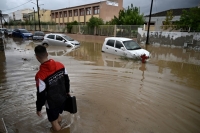أحد السكان المحليين يسير في شارع غمرته المياه/ وكالة الأنباء الليبية