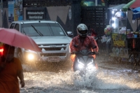 مركبات تتحرك في شارع غمرته المياه أثناء هطول أمطار غزيرة في بانكوك- رويترز 