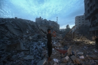 فلسطينيون يتفقدون أنقاض برج دمرته غارة جوية إسرائيلية في مدينة غزة- د ب أ