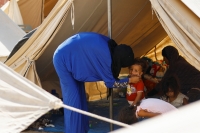 طفل ينظر بينما يحتمي الفلسطينيون في مخيم بمركز تديره الأمم المتحدة- رويترز
