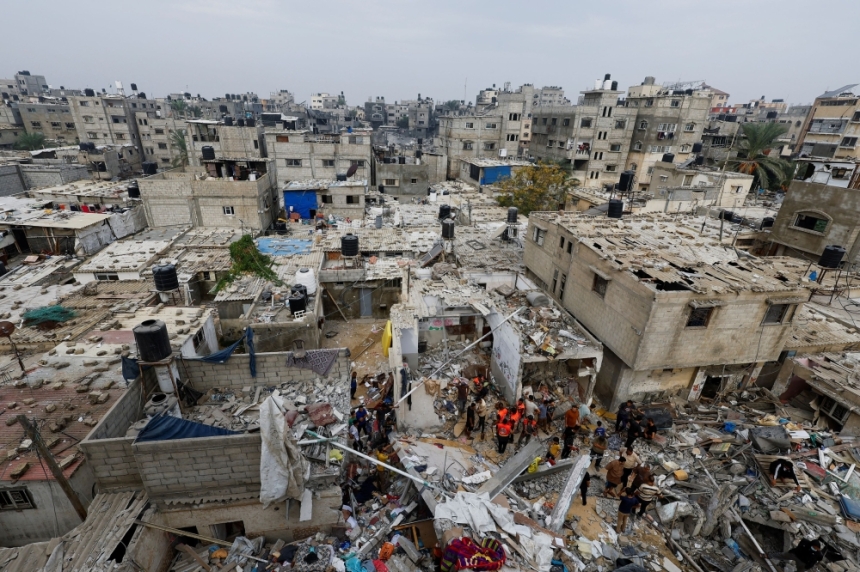 أفراد الطوارئ يتفقدون الأضرار في موقع الضربات الإسرائيلية على المنازل - رويترز