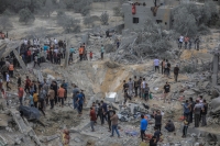 فلسطينيون يتفقدون أنقاض مبنى مدمر في أعقاب غارة للاحتلال- د ب أ 