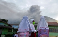 سيدات إندونيسيات يتابعن ثوران البركان - رويترز