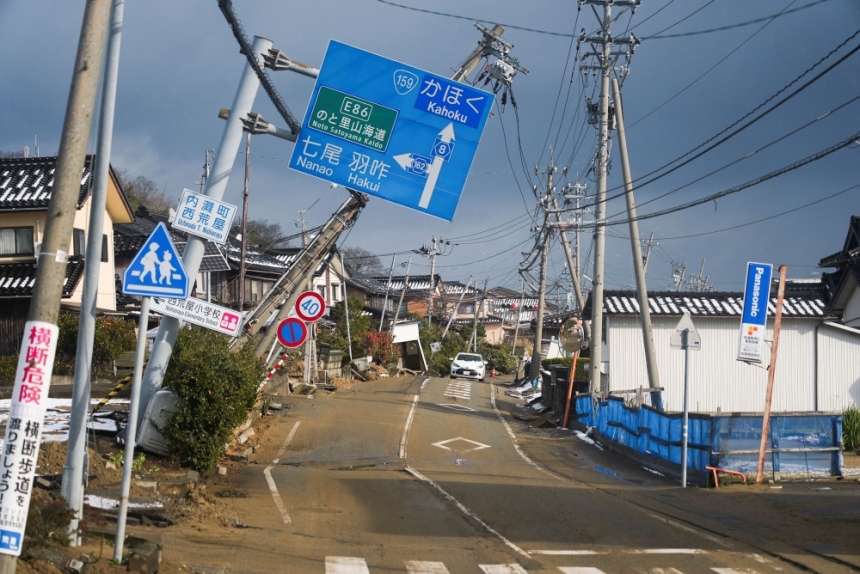 لافتات ملتوية معلقة فوق طريق تضرر في زلزال - اليابان