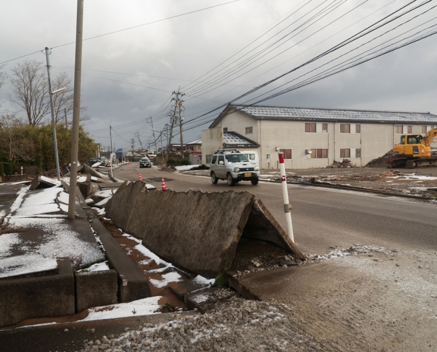 سيارة تمر بجوار رصيف تضرر في زلزال اليابان - رويترز 