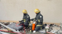 رجلا إطفاء يباشران العمل في موقع الحريق
