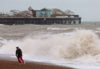 رد فعل شخص على الشاطئ مع تشكل أمواج كبيرة قبل وصول العاصفة جوسلين إلى برايتون بجنوب بريطانيا - رويترز