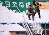رجل يزيل الثلوج بعد عاصفة ثلجية في الصين - رويترز 