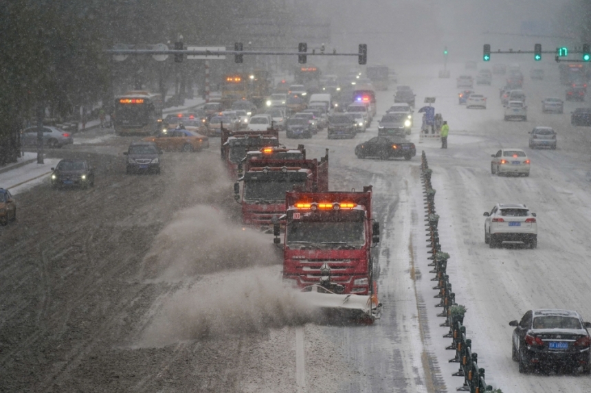 مركبات إزالة الثلوج تتحرك في أحد الشوارع وسط عاصفة ثلجية في الصين- رويترز 