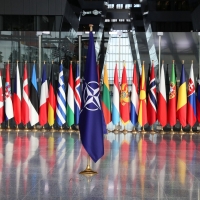 أعلام الدول المنضوية في الناتو يتقدمها علم الحلف (رويترز)