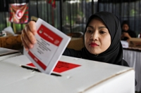 امرأة تدلي بصوتها في مركز اقتراع على مشارف جاكرتا بإندونيسيا- رويترز