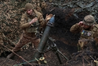 جنود أوكرانيون يطلقون قذيفة هاون باتجاه القوات الروسية- رويترز