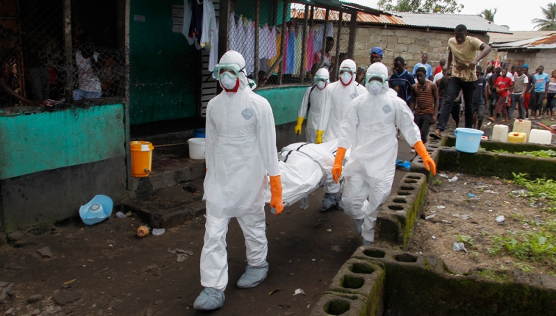 موظفي صحة يحملون أحد ضحايا إيبولا في ليبيريا (أ ف ب) 