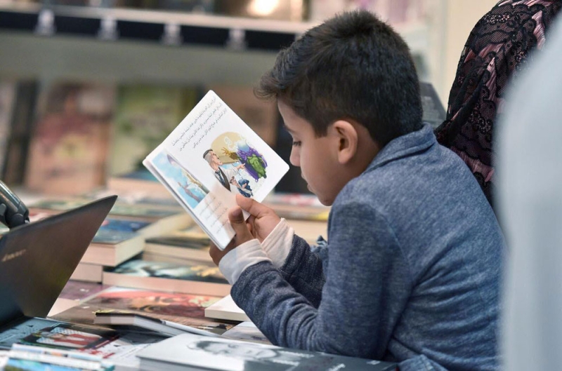 طفل مستغرق في قراءة قصة قصيرة للأطفال (واس)