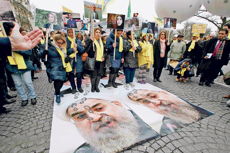 متظاهرون يدوسون على صور روحاني