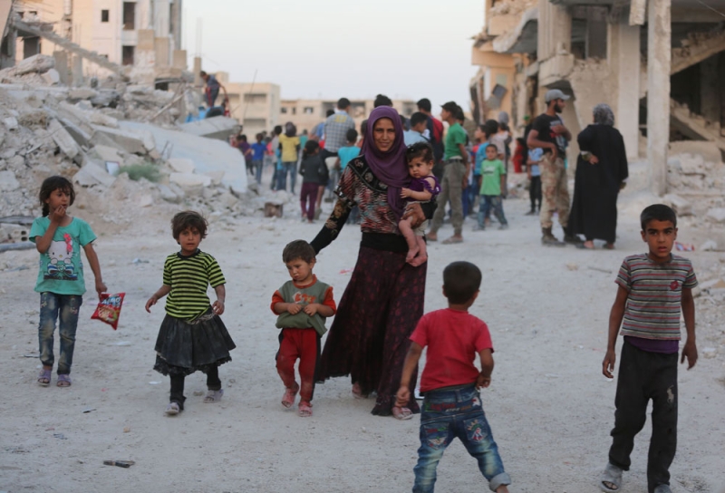 أطفال سوريون فروا من ديارهم يلعبون وسط أنقاض المباني في الغوطة (أ.ف.ب)
