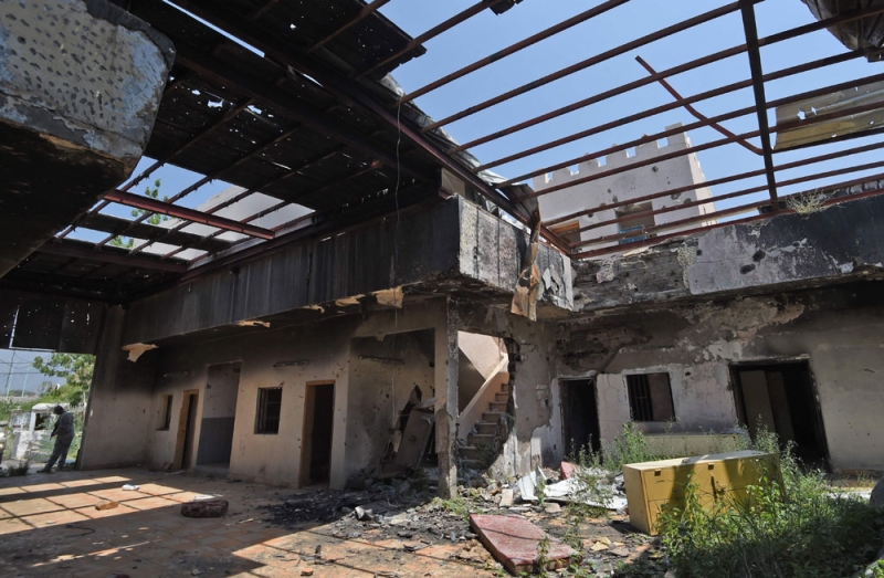 جندي سعودي داخل مبنى دمرته قذائف الحوثيين بقرية الخوبة جنوب جازان (أ ف ب)