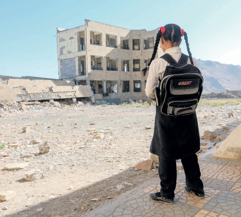 طفلة تقف أمام أنقاض مبنى دمره قصف الميليشيا لتعز (أ ف ب)