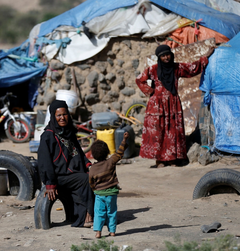نساء يمنيات يقفن خارج كوخ في مخيم لمشردي الحرب بالقرب من صنعاء (رويترز)