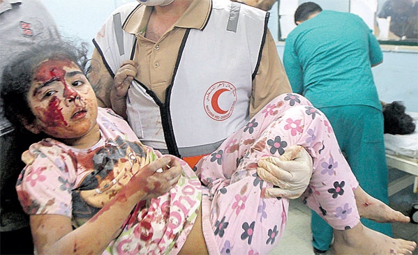  مسعف فلسطيني يحمل فتاة جريحة إلى مستشفى خان يونس في جنوب قطاع غزة	