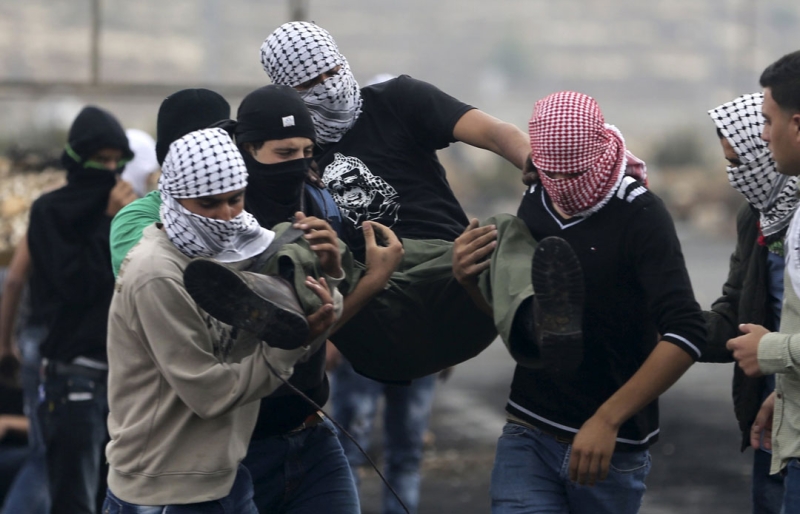 فلسطينيون يحملون مصابا جراء المواجهات في رام الله اليوم (رويترز) 