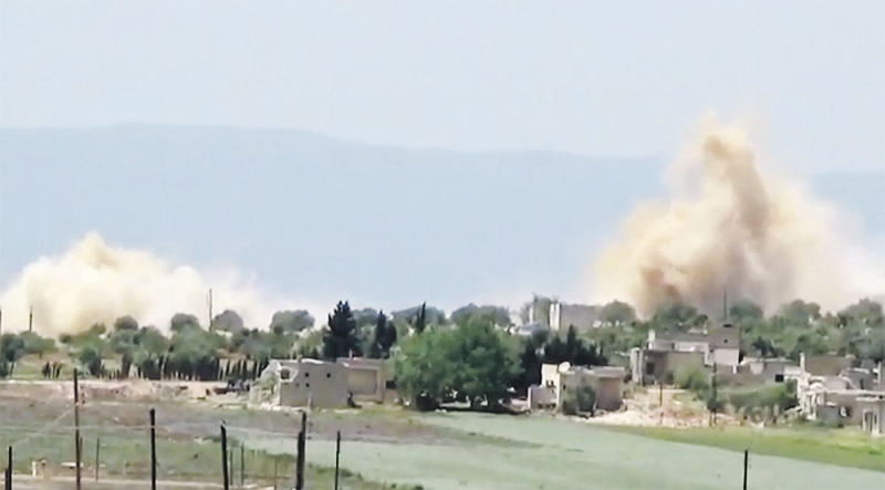 الدخان يتصاعد بعد غارة لطيران الأسد على اللطامنة في ريف حماة (رويترز)