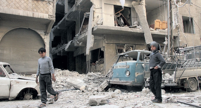 صبية سوريون وسط دمار خلفه قصف طائرات النظام على مدينة دوما (أ.ف.ب)