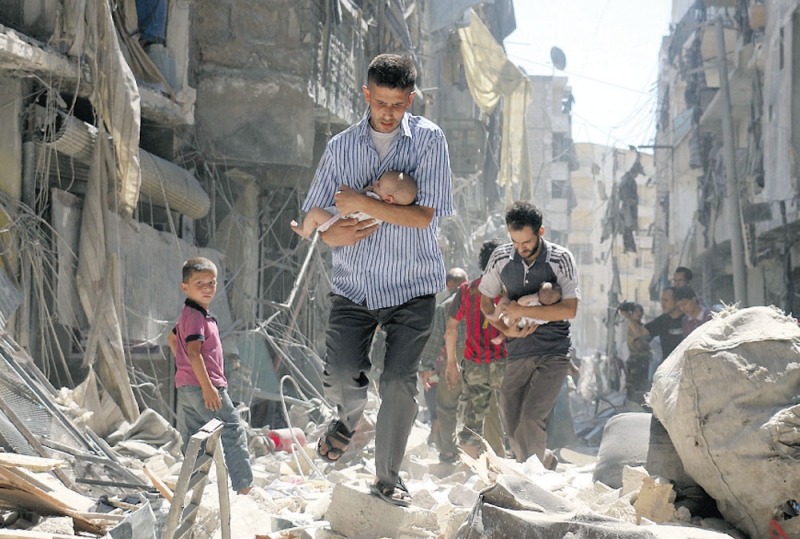 اخراج أطفال من مبانٍ دمرها طيران الأسد بحي الصالحين سبتمبر الماضي (رويترز) 