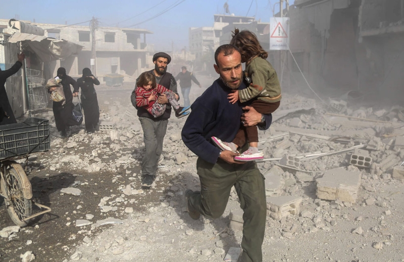 سوريون يهرولون هربا بعد غارة جوية على الغوطة (أ ف ب)