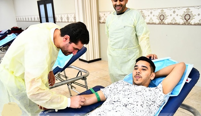 أحد الشباب أثناء تبرعه بالدم (اليوم)